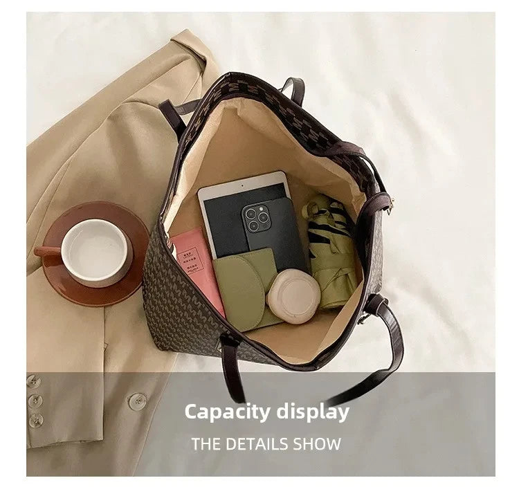 A faux leather letter-print tote bag is shown open, displaying various small items like a smartphone and notebook.