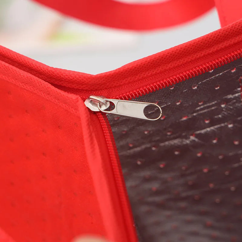 Close-up of a red insulated tote bag showing an aluminum zipper pull on the interior lining.
