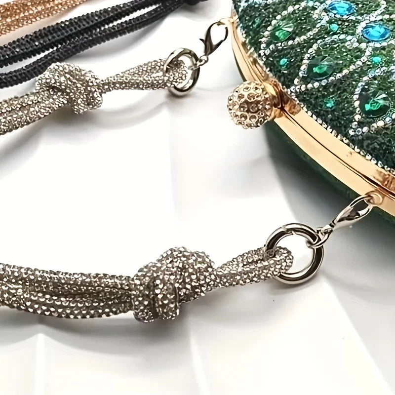 A close-up of a crystal rhinestone handbag chain strap featuring textured links and knot details against a green background.