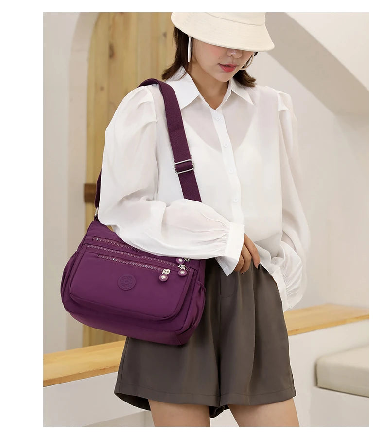 A woman wearing a white shirt and skirt holds a purple waterproof nylon crossbody shoulder bag.