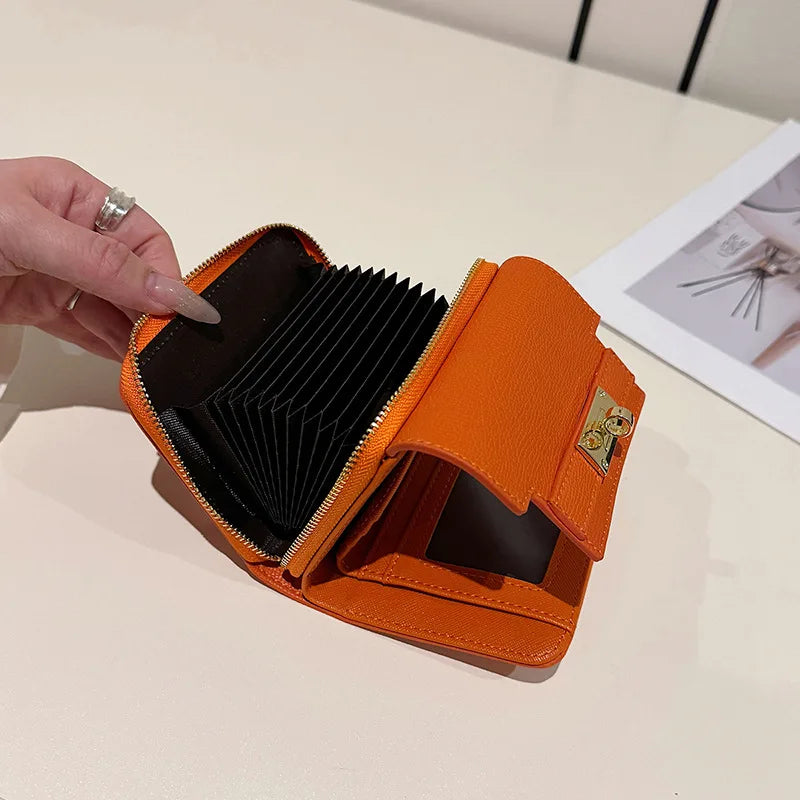 An orange multi-slot card holder is shown open on a light surface.