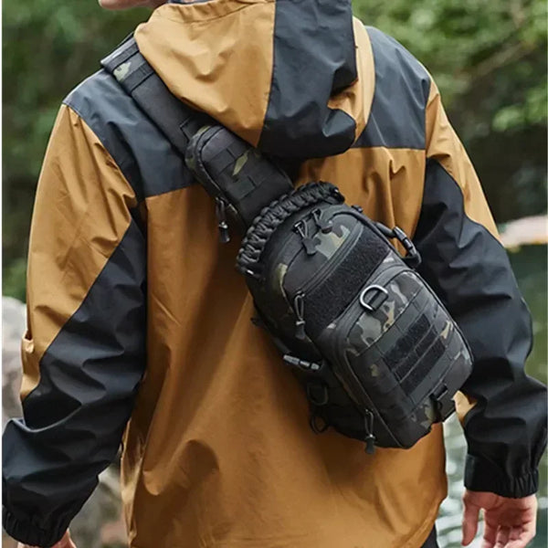 A person wearing a tan and black waterproof jacket is carrying a tactical chest bag on their back.