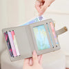 A light gray minimalist wallet is shown being held and opened to display various cards and IDs.