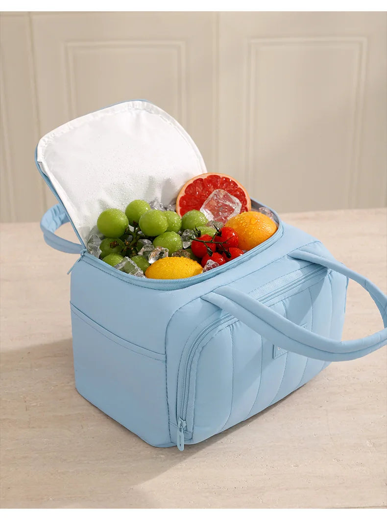 Bolsa térmica acolchada azul claro llena de fruta fresca y hielo