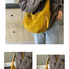 Eine Frau hält eine senffarbene Nylon-Crossbody-Handtasche mit goldenen Schnüren vor ihren Körper.