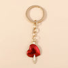 Gold chain keychain featuring a red heart pendant with a silver sun eye charm.