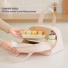 A hand is opening a pink insulated lunch tote with an inverted design to access contents easily.