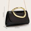 A black leather clutch purse with a gold-toned handle is displayed against a light background.