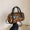 Designer Hobo-Bag mit Leopardenmuster in Braun und Schwarz, gehalten von einer Person.