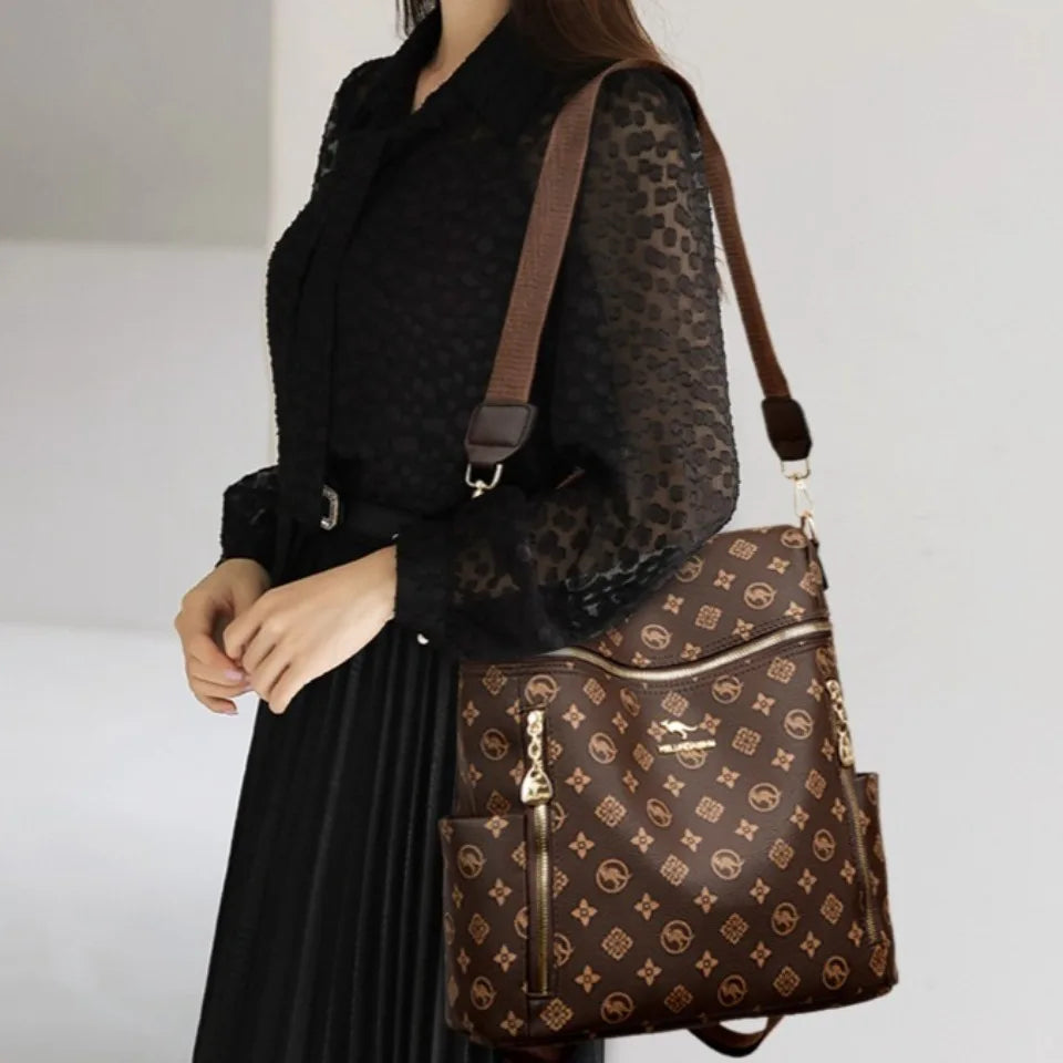 A woman wearing a black sheer top and long black skirt carries a brown leather backpack.
