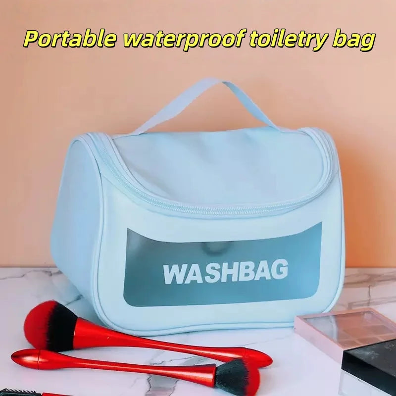 Sac de toilette portable bleu clair étiqueté WASHBAG avec applicateurs rouges sur une surface blanche.