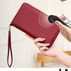 A hand holds a red PU leather zipper wallet with an RFID protection shield, emphasizing theft protection for data safety.