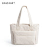 Sac cabas matelassé beige avec anses beige clair et détails de couture carrée.