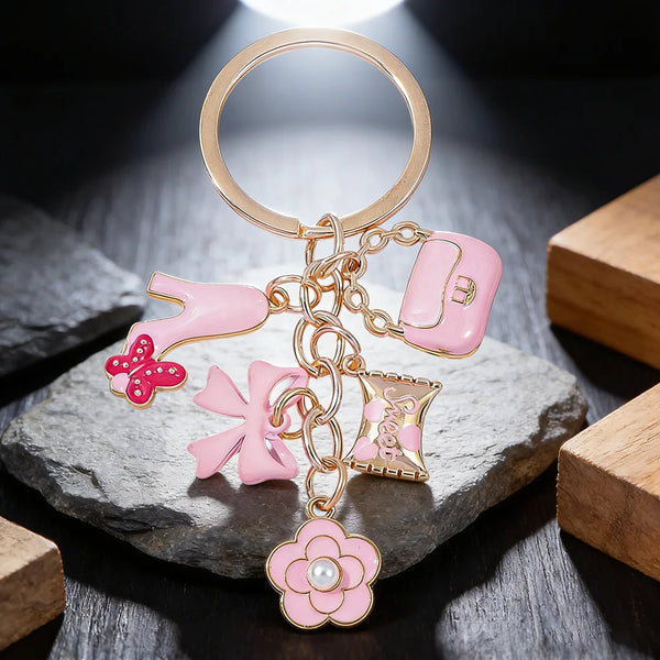Pendentif de cœur doré et rose avec nœud floral sur anneau circulaire, exposé sur une pierre grise.