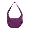 A purple canvas crossbody bag with a strap visible.