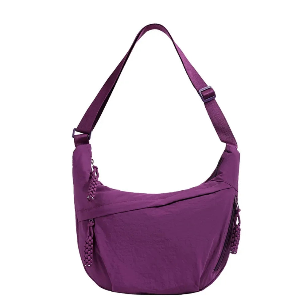 A purple canvas crossbody bag with a strap visible.