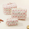 A set of pink and white quilted cotton makeup organizers featuring a floral pattern.