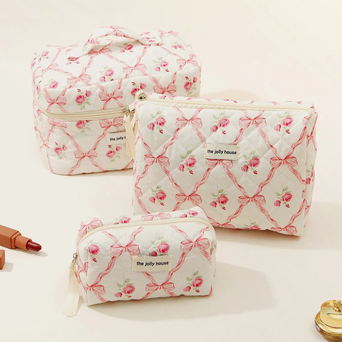A set of pink and white quilted cotton makeup organizers featuring a floral pattern.