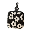 Black coin purse with a white floral pattern and a black hook closure.