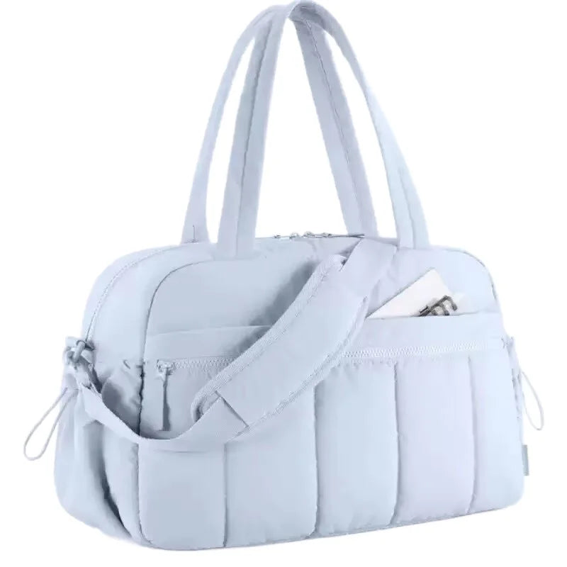 A white versatile large capacity travel and fitness bag with padded straps.