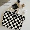 A black and white checkered plaid cosmetic storage bag is shown with various beauty products on a white surface.