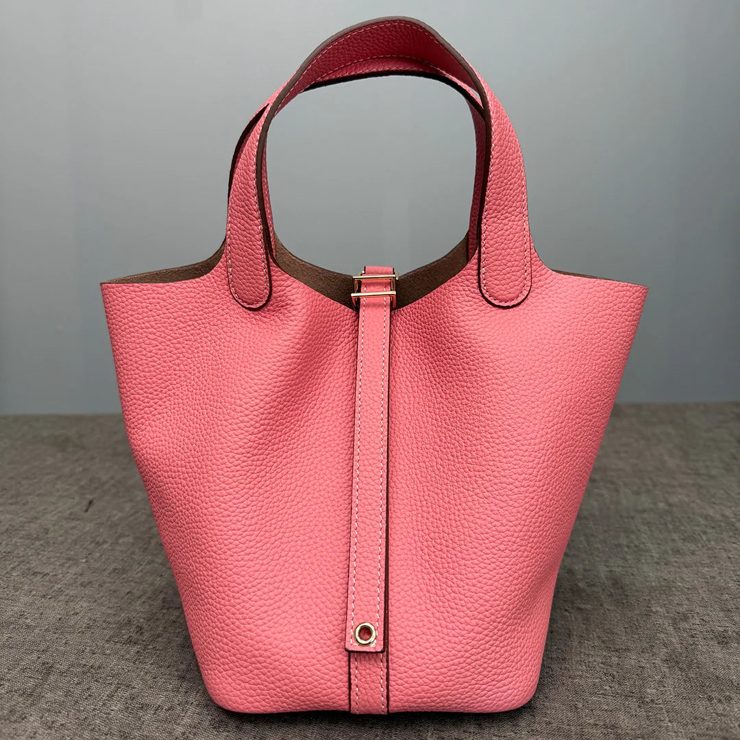 A pink genuine leather bucket bag with a smooth texture and a pink lining visible.