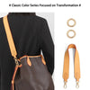 A close-up of a brown leather bag with an adjustable wide shoulder strap worn over a black blazer.