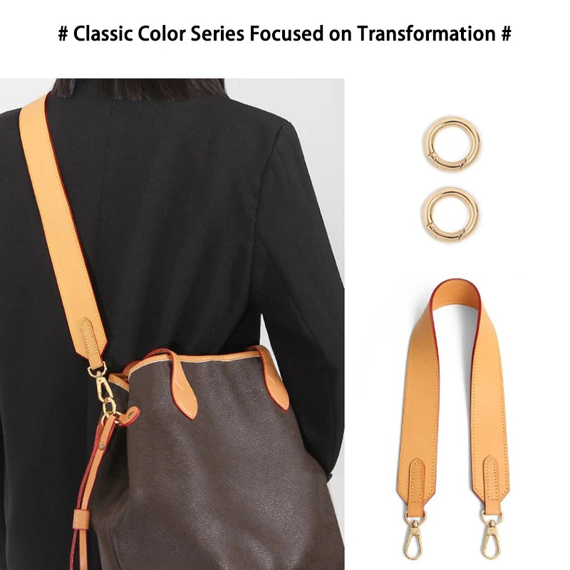 A close-up of a brown leather bag with an adjustable wide shoulder strap worn over a black blazer.