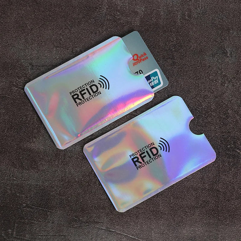 Two plastic card sleeves with RFID protection labels are shown on a dark surface.