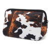 A black and white cow print cosmetic organizer bag with a zippered closure.