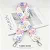 A white and pink floral patterned nylon shoulder strap for bags and purses displayed on a white box.