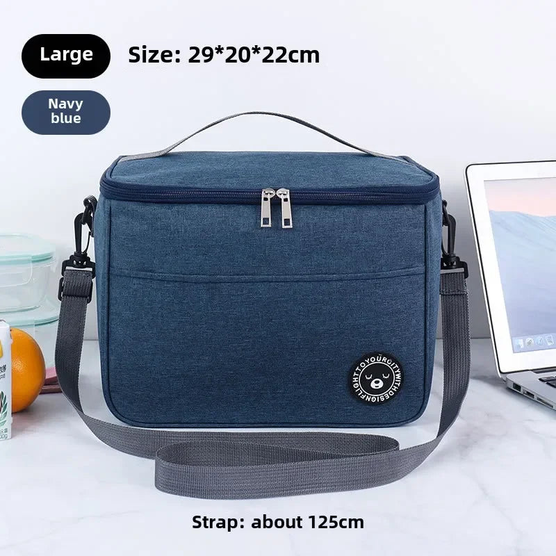 Navy blue insulated portable lunch bag with a gray shoulder strap shown on a white surface.