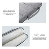 A gray laptop sleeve with a padded, fluffy lining and a strap for easy carrying.