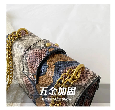 A close-up of an elegant retro crossbody bag featuring a brown and black snakeskin pattern with gold chain detailing.