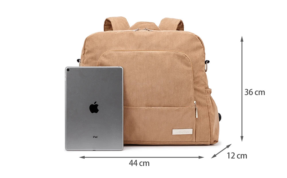 A tan corduroy diaper backpack next to an iPad, showing its dimensions.