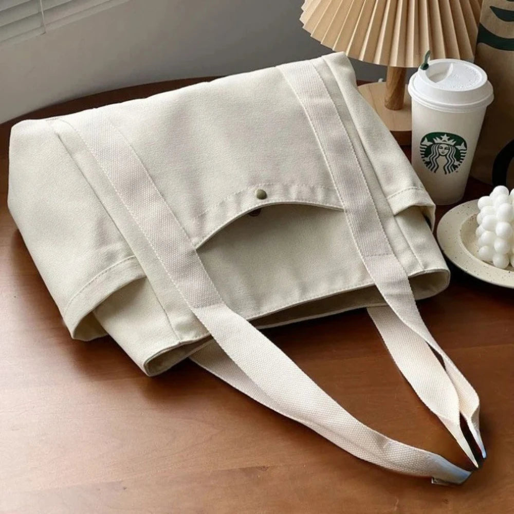 Una bolsa de tela beige colgada sobre una superficie de madera.