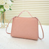 A light pink beaded square crossbody bag with a pink adjustable strap resting on a white surface.