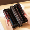 A brown vintage PU leather zippered wallet with multiple compartments is shown open in a hand.