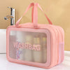 A pink clear plastic washbag with pink straps and a mesh pocket, sitting on a white surface.
