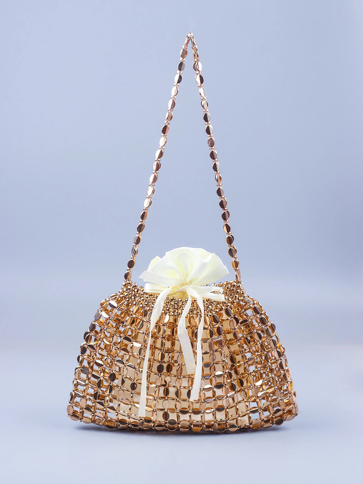 A handmade dumpling bag made of gold and silver beads tied with a cream ribbon.