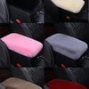 A set of plush car armrest cushions in various colors including black, cream, pink, gray, and red.