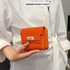 An orange multi-slot card holder is held by a person wearing a white shirt.