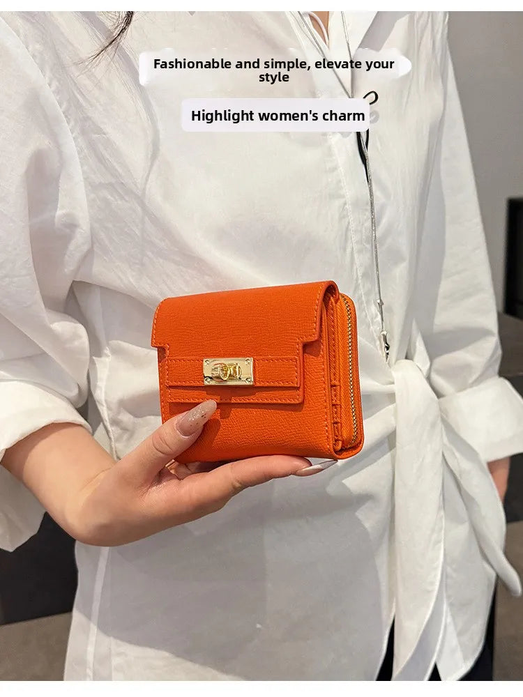 An orange multi-slot card holder is held by a person wearing a white shirt.