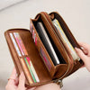 A brown vintage double-zipper wallet is shown open, displaying various cards and a smartphone.