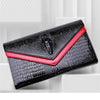 Black alligator pattern leather clutch bag with a red accent edge