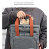 Una persona sostiene una bolsa térmica gris con asa naranja, mostrando su diseño duradero.