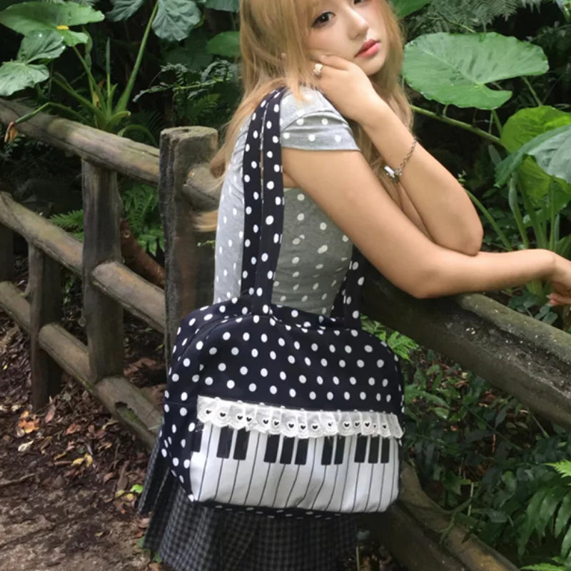 A woman wearing a grey top rests her hand on a wooden railing while holding a musical note tote bag with piano lace trim and 