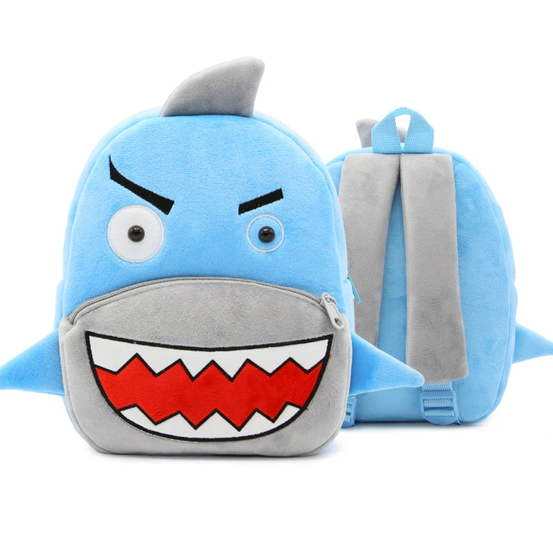 A blue cartoon dinosaur plush backpack with a gray strap and an open mouth showing sharp teeth.