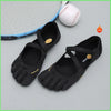 Black women's barefoot five-toe shoes with an adjustable strap and a baseball nearby.