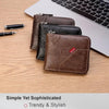 A stack of brown and black leather bifold wallets resting on a wooden surface next to a silver pen and a laptop keyboard.
